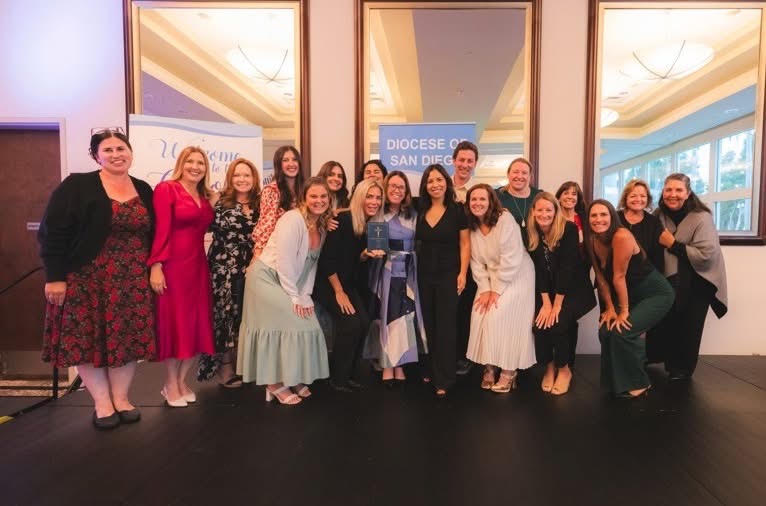 Saint James Academy faculty and staff gathered on stage holding the Catholic School of the Year award at the Diocese of San Diego ceremony